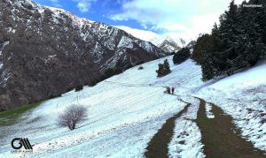 two people are walking with a little snowy trail in alamut valley