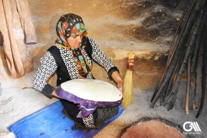 a woman is making bread in tandoor with a traditional way