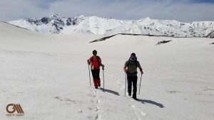 the italian couple is trekking on the snow in alamut valley